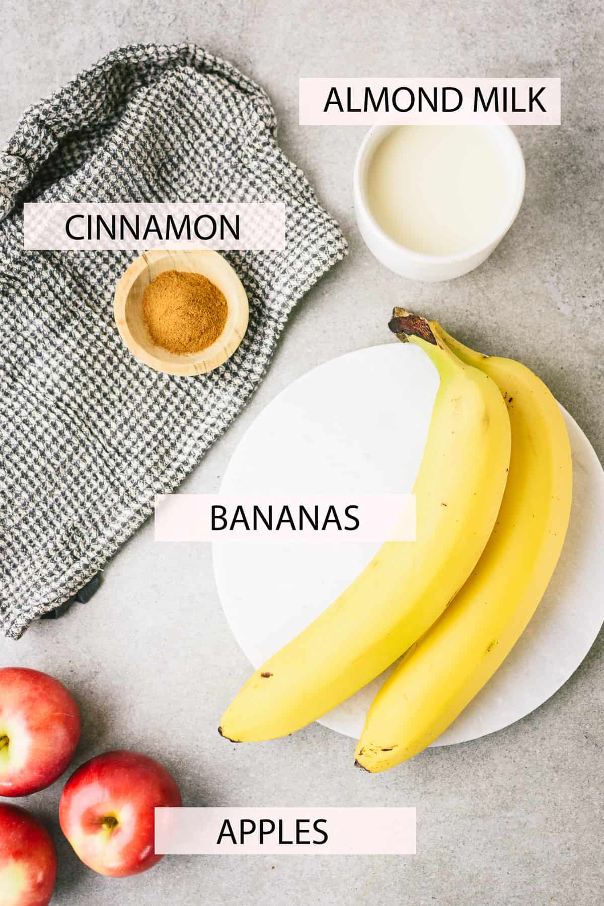 Labeled picture of ingredients, including almond milk, cinnamon, two bananas and three apples.