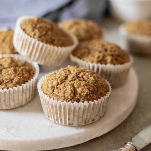 Oat bran banana muffins on round white marble tray.