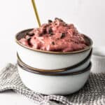 Cherry nice cream topped with chocolate in a bowl.