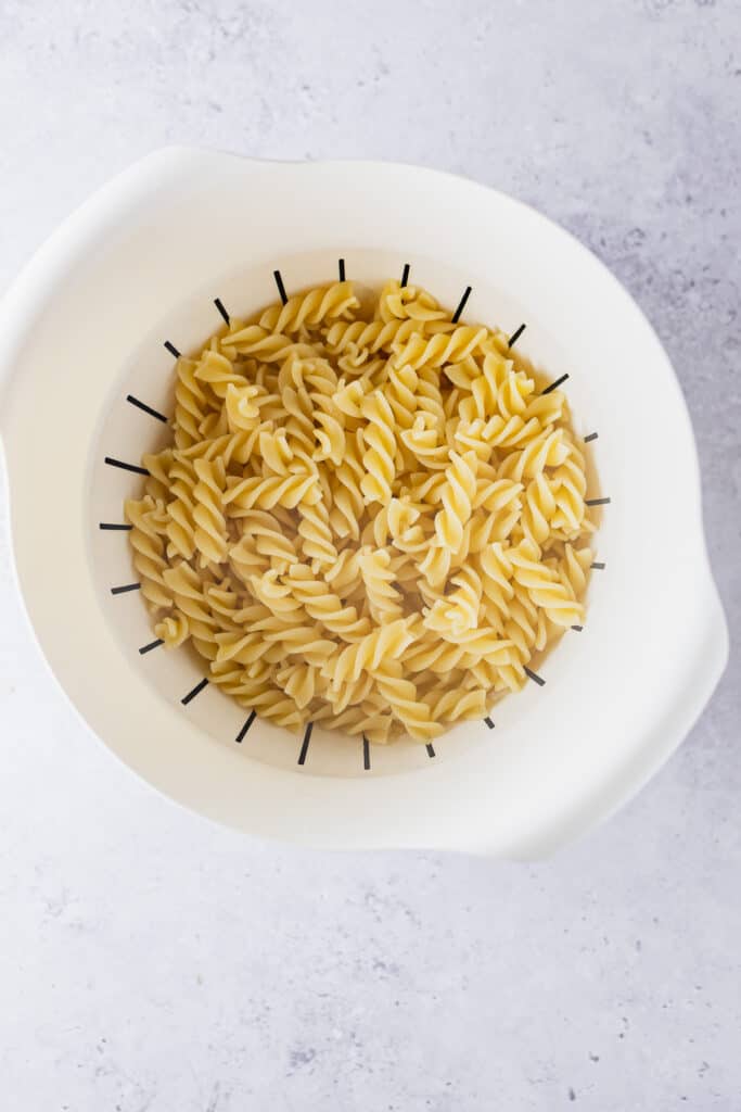 Cooked pasta in a strainer.